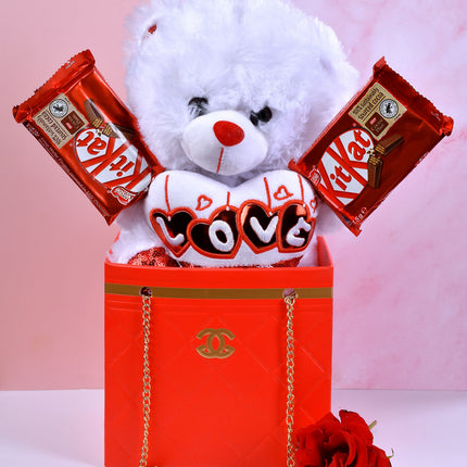 The Chanel Bag gift set with teddy bear, KitKat chocolates, heart cushion, and red rose.