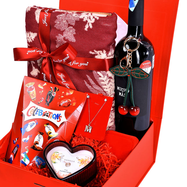 The Indulge Package with wine, chocolates, blanket, jewellery, and gift items in a red box.