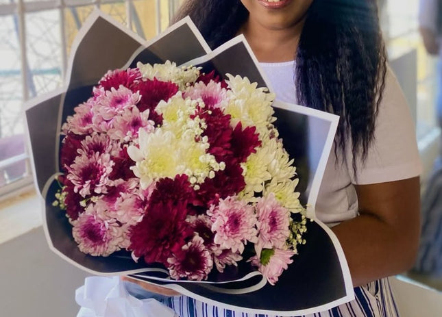 For Her bouquet with red, pink, and white chrysanthemums wrapped in elegant black and white paper.